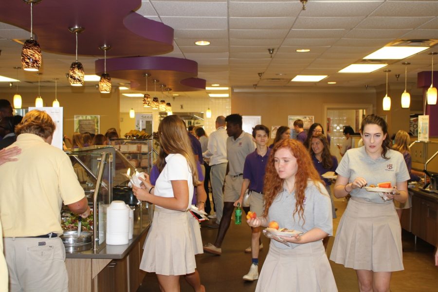 Our cafeteria is in many ways the center of student life. Students stand crowded in the lunchroom. 
