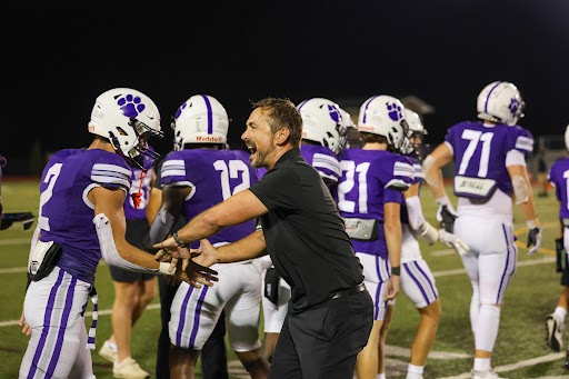 Coach Wayne Groves high-fiving senior quarterback Sammy Kunczewski after the win against Whitefield Academy on Sept. 13.