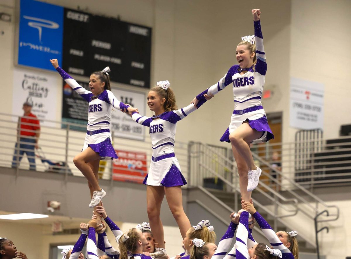 From left to right: Freshman Ella Nagle, juniors Heidi Holder and Ashlyn Garrett pose for the stunt