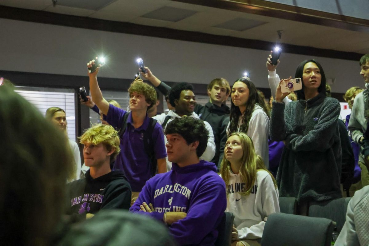 Students watch houses perform in the Christmas karaoke for the first point of RUMPUS 