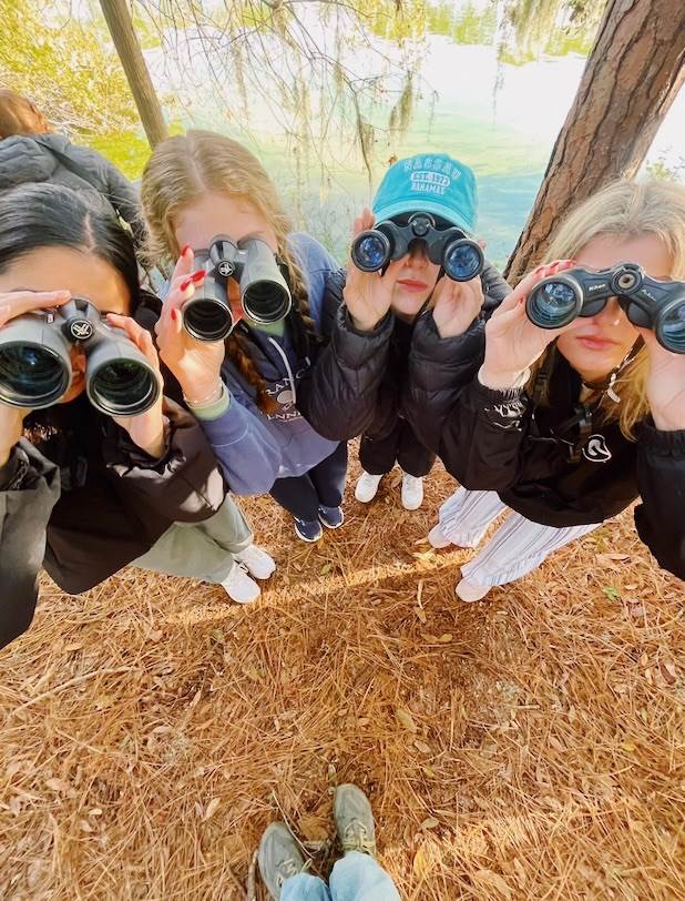 Members of the Zoology class pose for a picture with their binoculars.