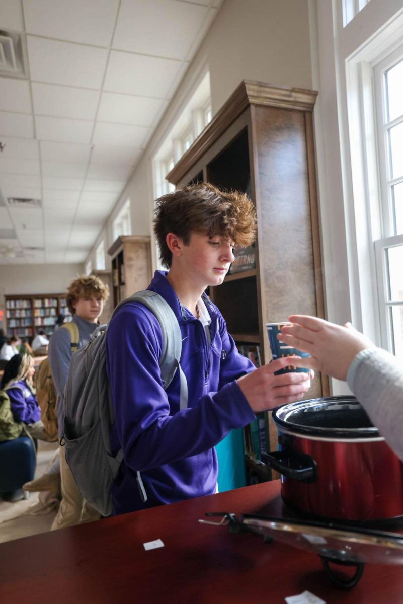 Freshman Levi Duggan receives his cider at the Cozy Christmas Cuppa held in the Library on Dec. 11th, 2024.