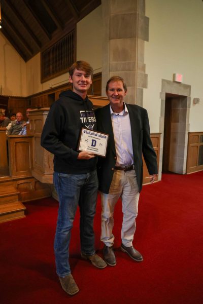 Senior Julian Lowrey poses with baseball coach Matt Larry at the Spring Sports Awards Assembly.