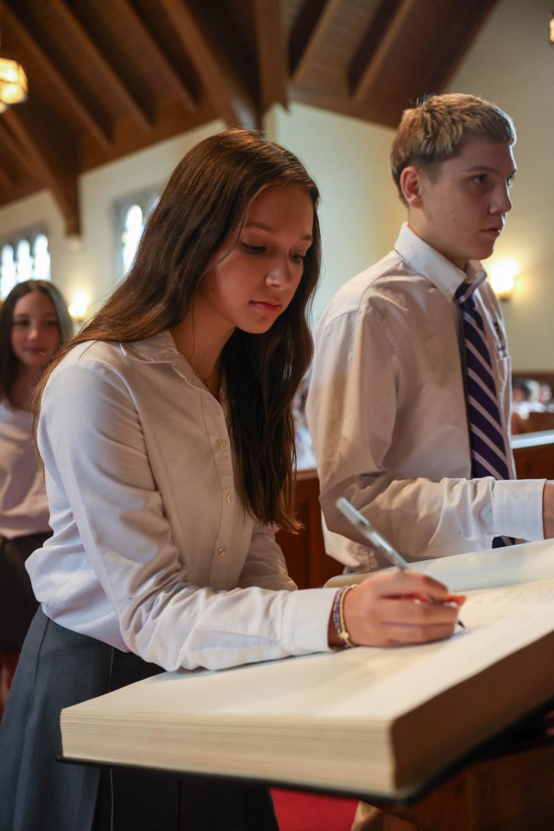 Freshman Olivia Crane signs the Honor Book, a tradition all freshmen participate in.