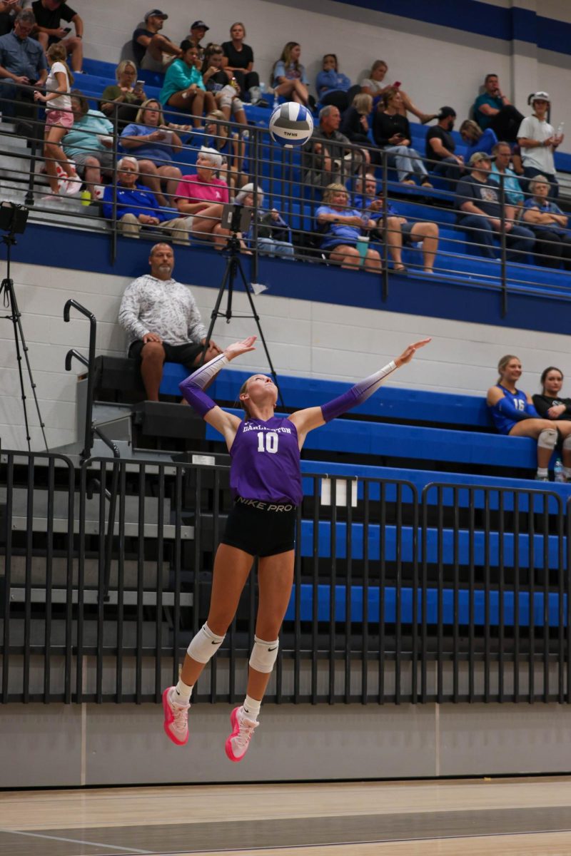 Senior Ruthie Brinson smashes the ball for a serve.