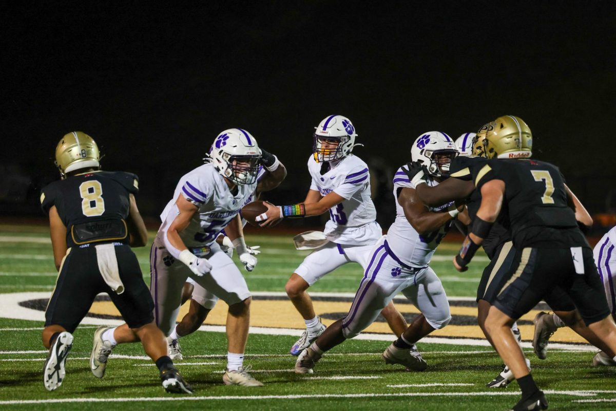 In this photo Levi Duggan is handing the ball off to Evan Parton.