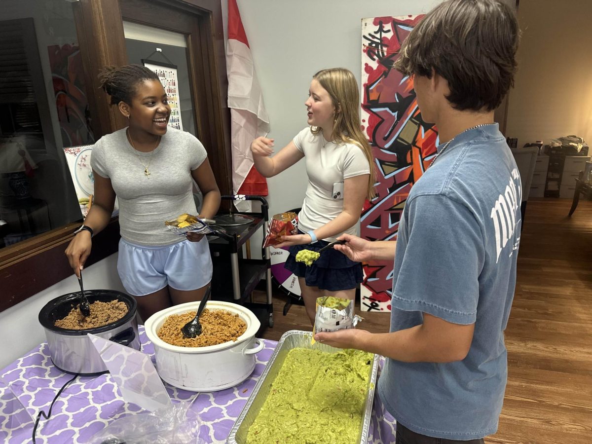 Sophomore Adam McMillan, Sophomore Veronica Rhode and Sophomore Nakami Karuthiru making walking tacos in the Student Center.