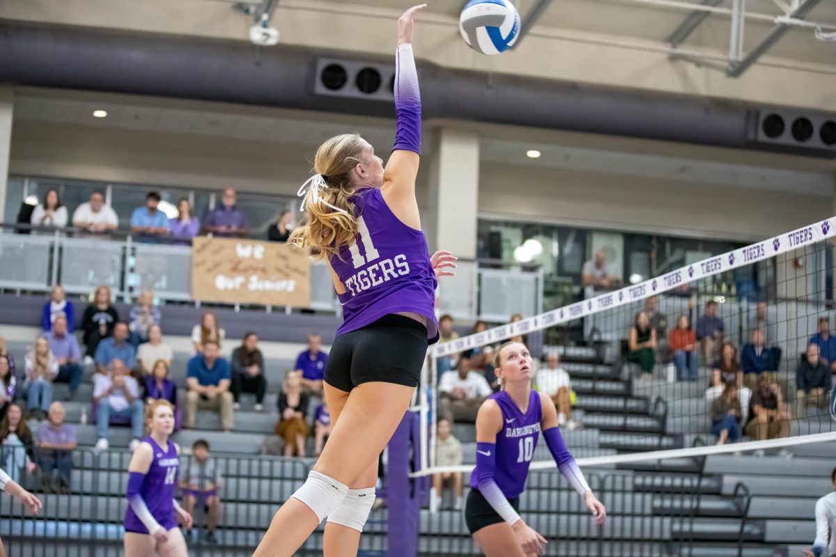 Junior Nora Knaak smashes the ball as Seniors Ava Ann Woods and Ruthie Brinson watch.