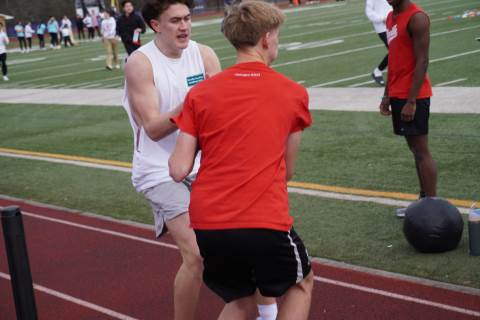 Junior Nate Pitts hands off a medicine ball to his teammate.