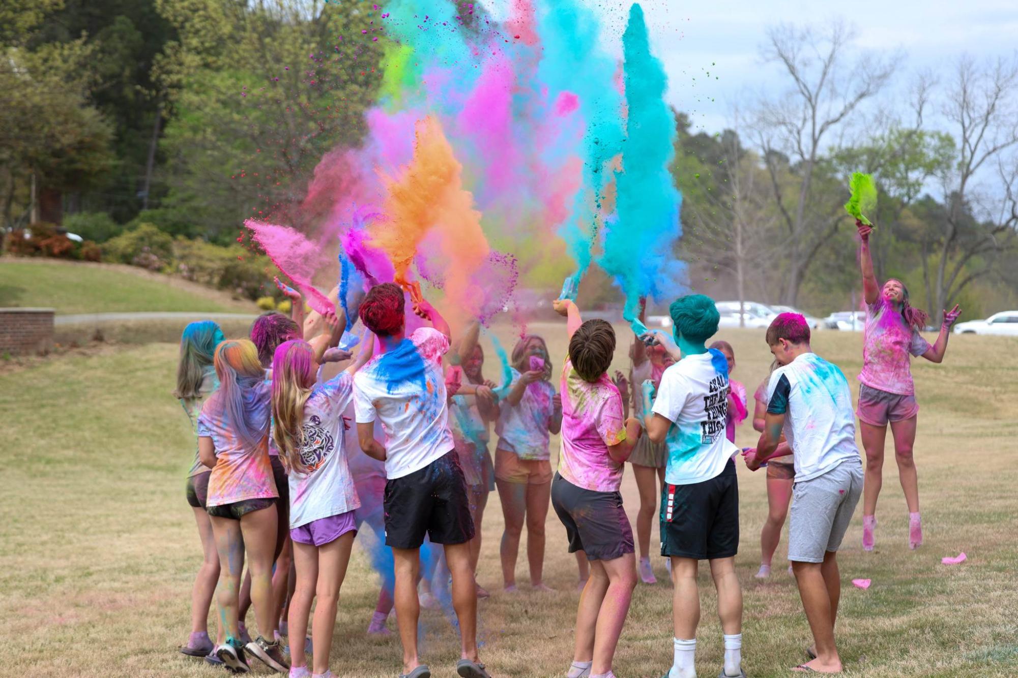 Students gather and throw colored powder in honor of Holi.