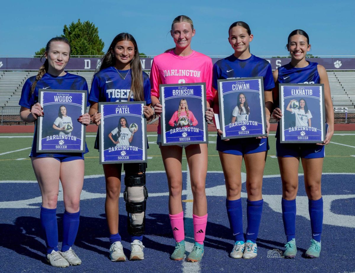 The five seniors on the Girls soccer team pose with their posters.